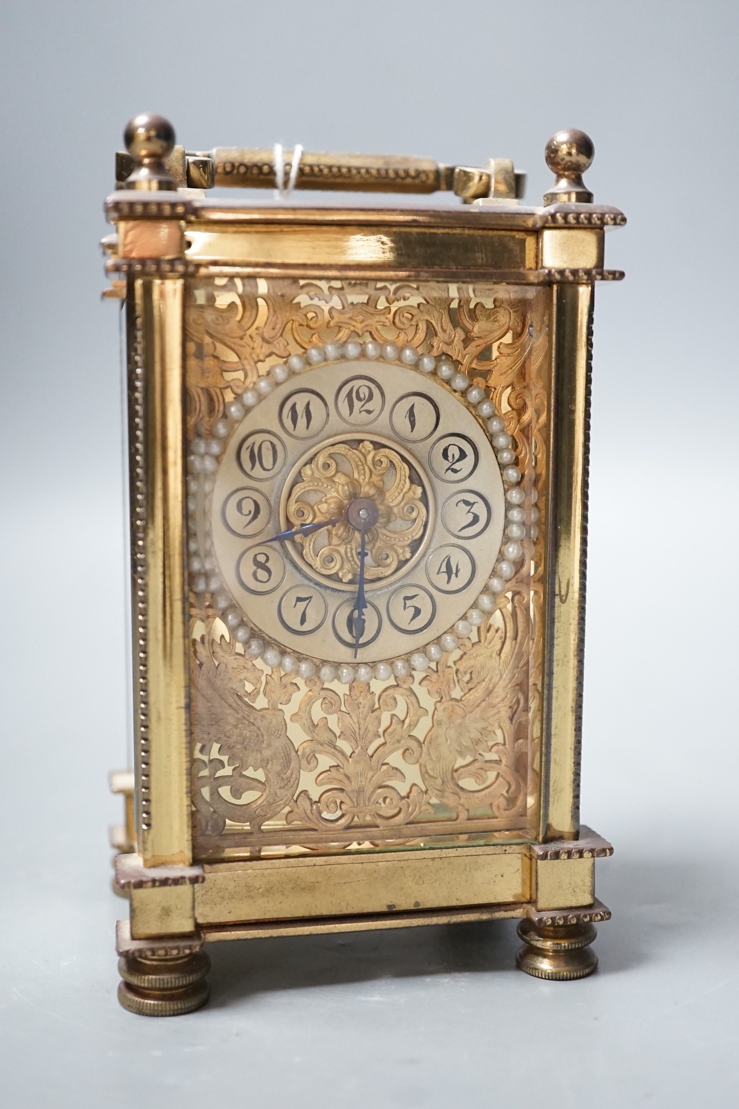 An Edwardian brass carriage timepiece, with pearl applied dial, 12cms high